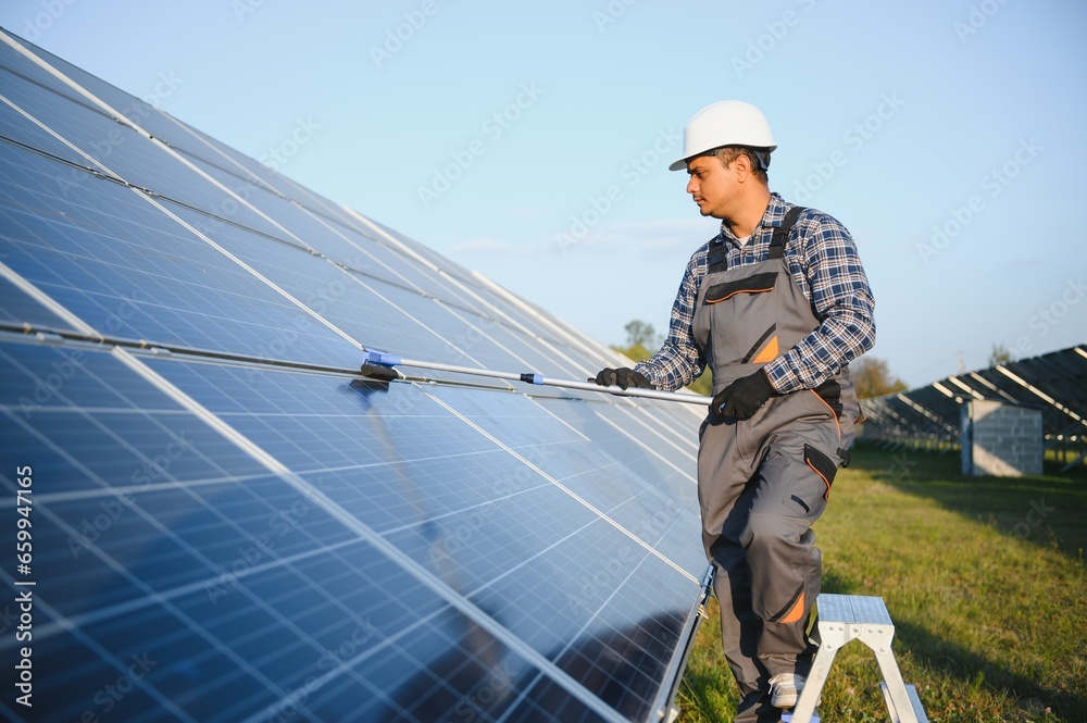 Indian worker cleaning solar panels Indian worker cleaning solar panels