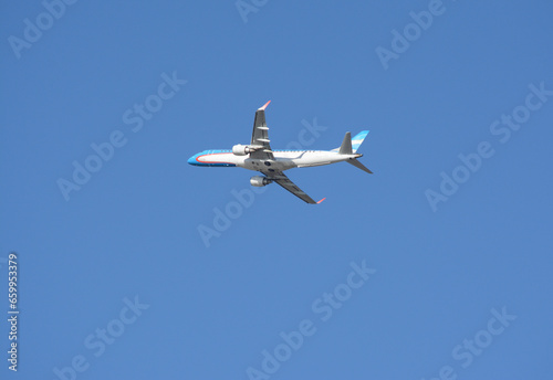 airliner flying in the blue sky, light blue and white commercial plane