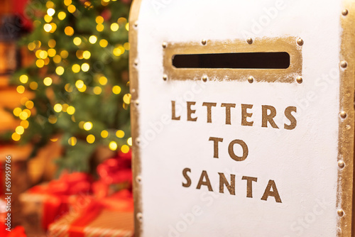 A letter box for Santa on background of a Christmas tree with defocus lights