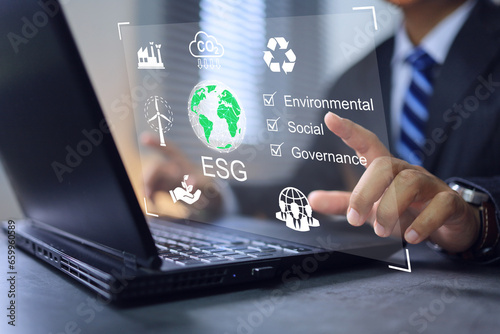 ESG environmental social governance concept. Businessman working on laptop concern co2 reduction emissions atmosphere, leading company take care environment conservation reducing carbon footprint. photo