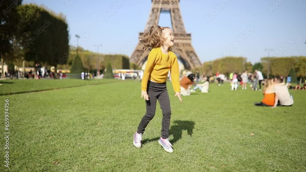 Adorable happy preschooler girl having fun near the Eiffel tower in Paris, France