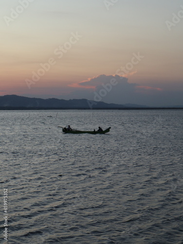 silhouette of fisherman on the lake at sunset 