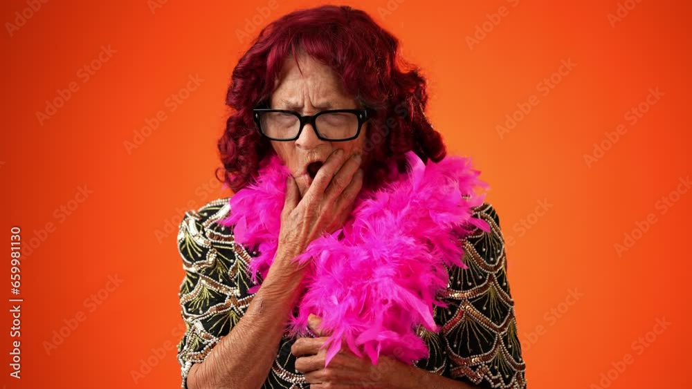 Portrait of toothless funny elderly senior old woman with wrinkled skin looks at camera gives mind blown gesture showing explosion of ideas posing isolated on orange background with copy space. 