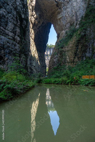 The water reflection of Qinglong Bridge in Wulong Karst, Chongqing, China, presents a serene and picturesque scene. photo