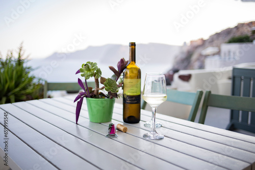White wine served on a cold wineglass on a wooden table in Santorini  Greece