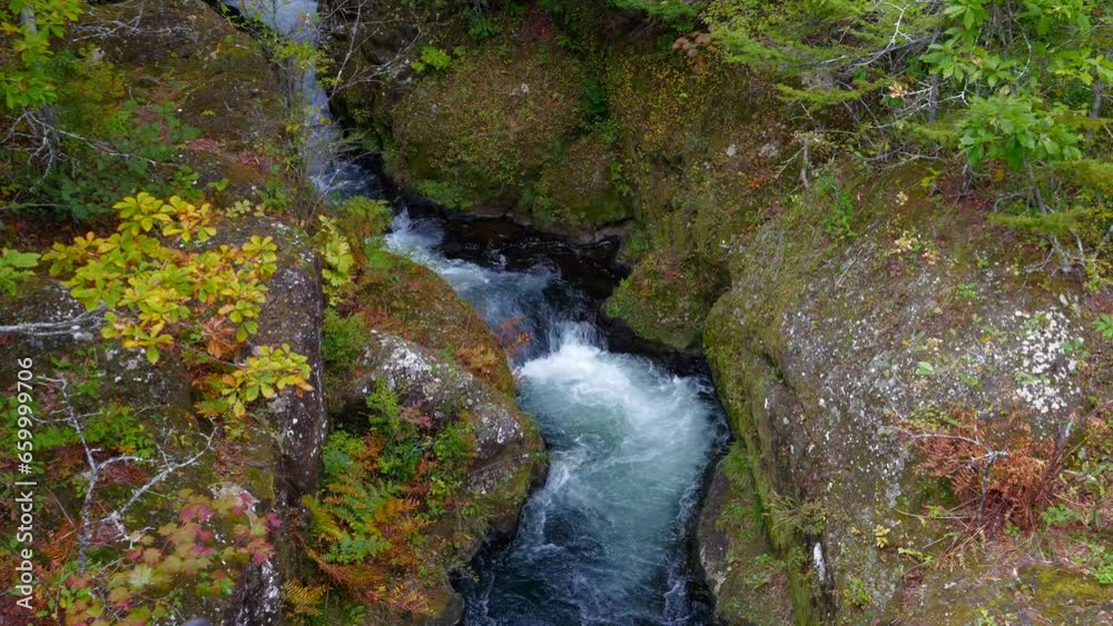 A view of water cascading down between brown rocks. A view of water cascading down between brown rocks.