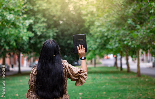teen woman hand up holy bible nature