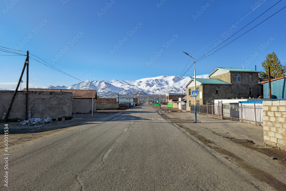 Northern Mongolia. The morning City is Ulgiy. The houses of the street stretch into the distance, to the snow-capped mountains.