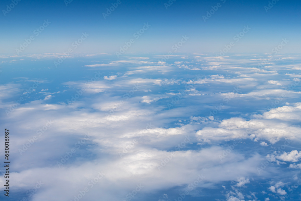 White clouds against the blue of the Pacific Ocean seen from a plane near the Hawaiian Islands

