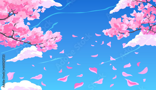 Pink blossoming sakura cherry branches with petals falling against the background of a bright blue sky with clouds.