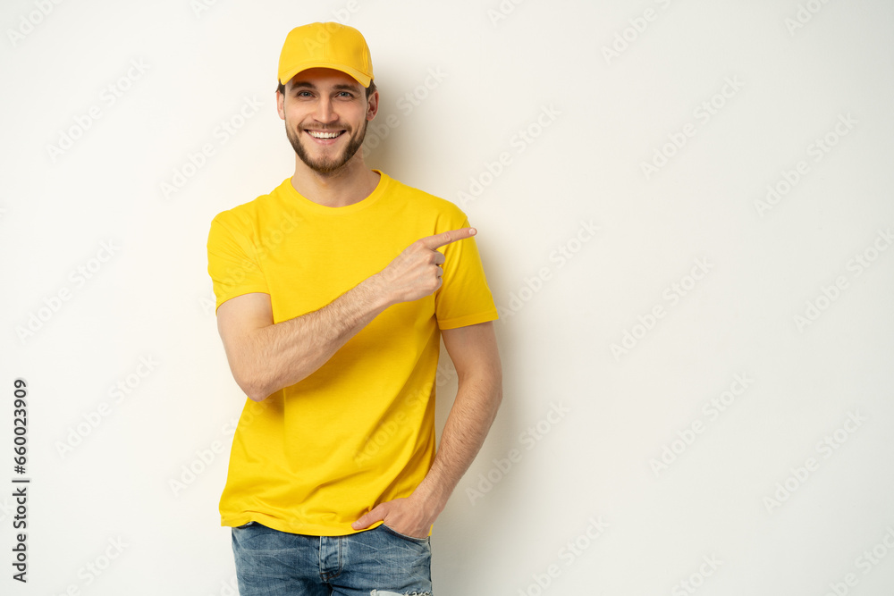 Delivery man in yellow uniform isolated on white background. Professional smiling confident male employee in cap, t-shirt courier dealer Delivery man in yellow uniform isolated on white background. Professional smiling confident male employee in cap, t-shirt courier dealer