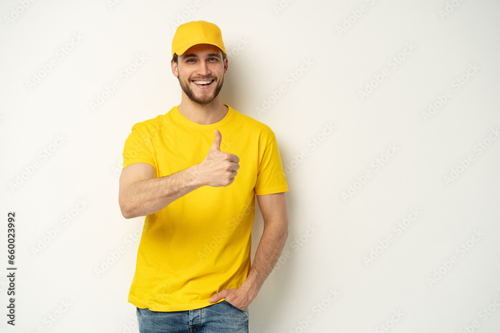 Delivery man in yellow uniform isolated on white background. Professional smiling confident male employee in cap, t-shirt courier dealer
