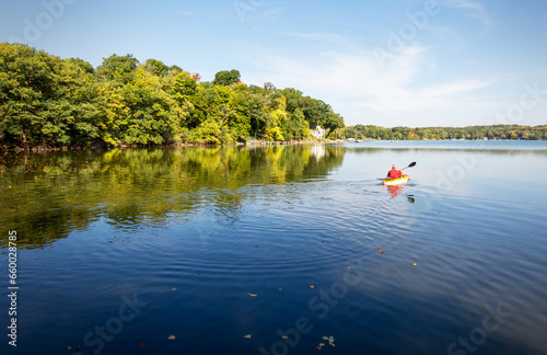 A Kayaker takes to the water on a warm October morning on a lake in Wisconsin. © Jennifer
