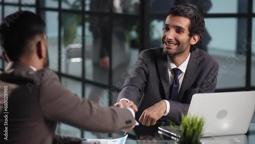 smiling businessman shaking hands with his business partner