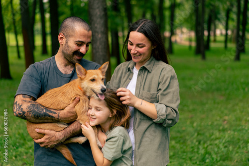 portrait of happy young family in park with dog dad mom daughter resting concept of trust care and family values
