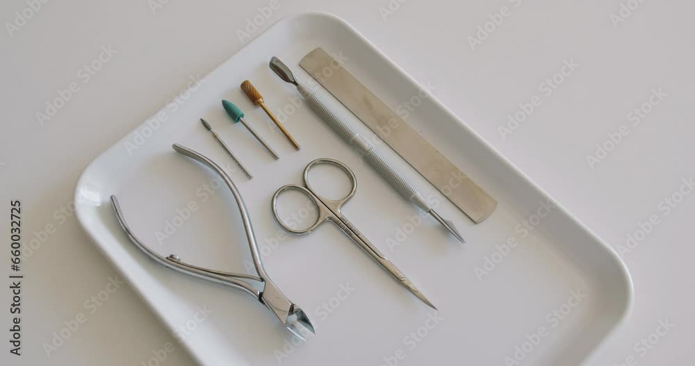 Top view on manicure tools on tray for nail care procedure at beauty salon. Professional instruments for fingernail treatment Top view on manicure tools on tray for nail care procedure at beauty salon. Professional instruments for fingernail treatment