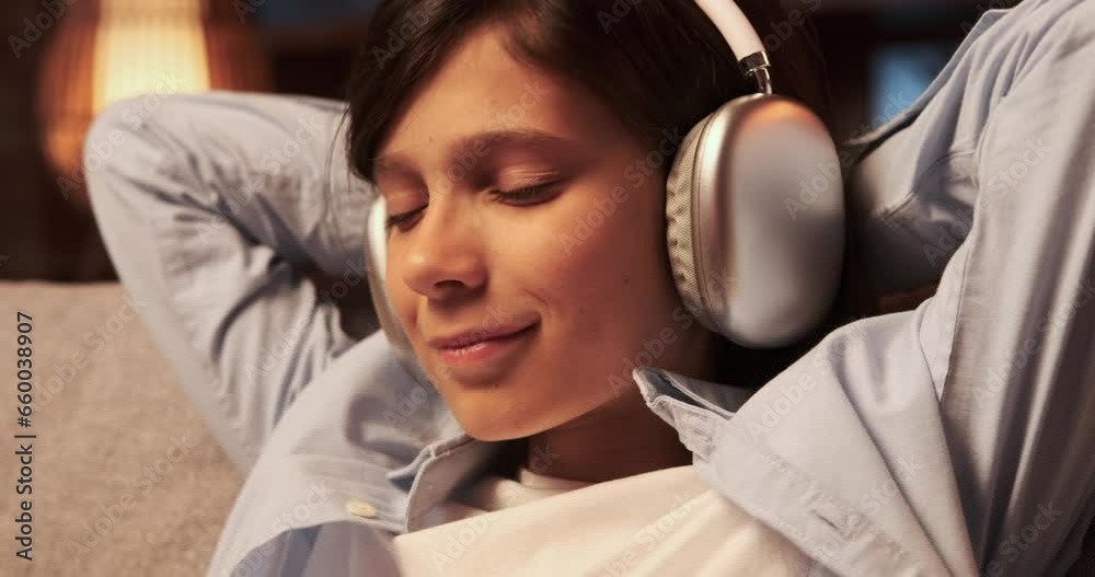 Schoolboy wears headphones, face portraying pure bliss as he savors the