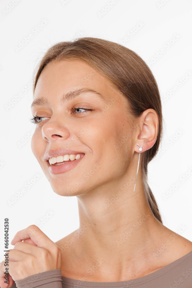Beautiful young girl with fresh healthy skin. Woman advertise ear-rings. White background. Earrings, ear caffs closeup. Blond european woman with long hair with big lips, pretty smile. Cosmetology Beautiful young girl with fresh healthy skin. Woman advertise ear-rings. White background. Earrings, ear caffs closeup. Blond european woman with long hair with big lips, pretty smile. Cosmetology