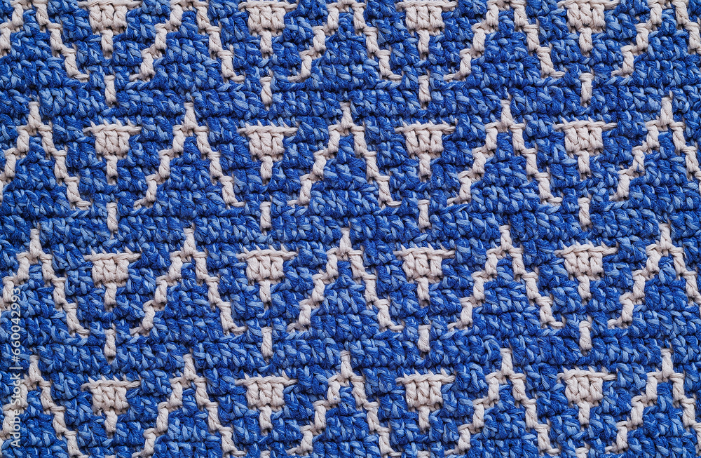 Knitted background. Blue white crochet texture with mosaic pattern. Knitted background. Blue white crochet texture with mosaic pattern.