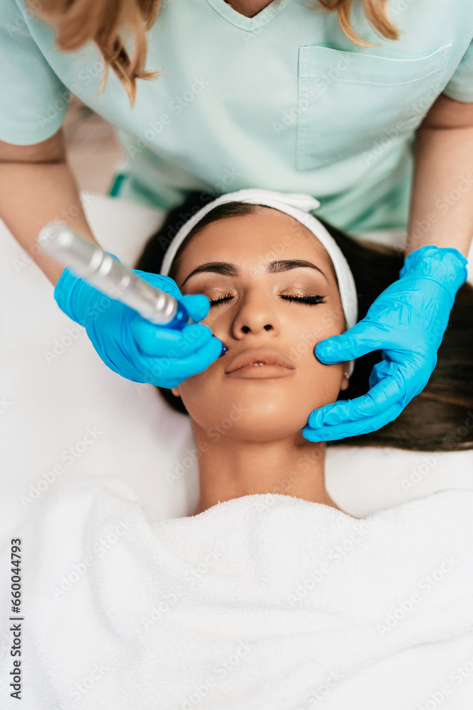 Professional cosmetologist making mesotherapy injection with dermapen on face for effective skin rejuvenation. Modern cosmetology spa treatment. Professional cosmetologist making mesotherapy injection with dermapen on face for effective skin rejuvenation. Modern cosmetology spa treatment.