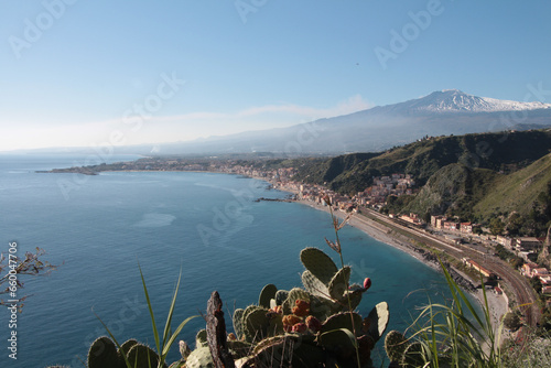 taormina sicily italy mount mt etna volcano giardini naxos next to ocean water shot from hill mountain high vantage point, ultra wide shot with cactus plant in front foreground photo