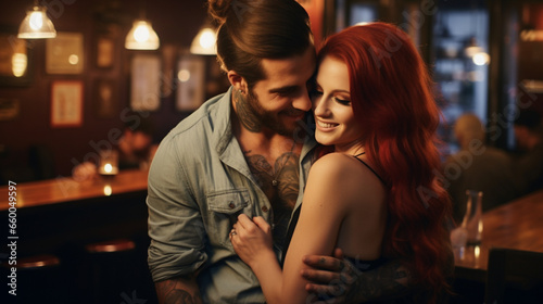 Beautiful young couple in love hugging and smiling while sitting in a pub