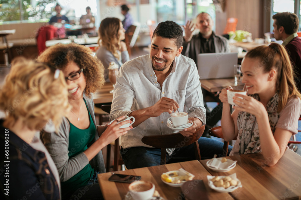 Group of young and diverse friends having coffee together in a cafe or bar Group of young and diverse friends having coffee together in a cafe or bar