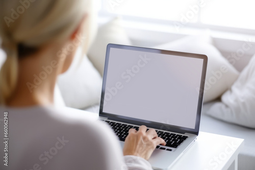 closeup female hand using white blank screen laptop online working in living room home working lifestyle photo
