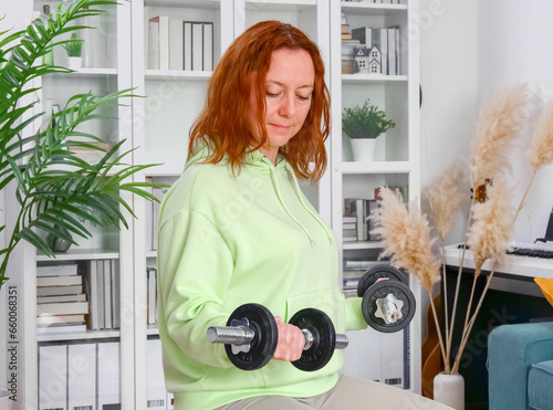 Obraz na płótnie woman doing sports exercises with fitness ball and dumbbells at home w salonie