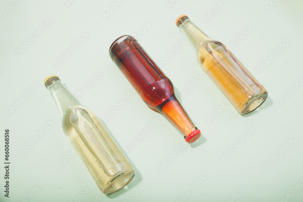 Three vibrant liquid-filled bottles set against a serene light green background. Three vibrant liquid-filled bottles set against a serene light green background.