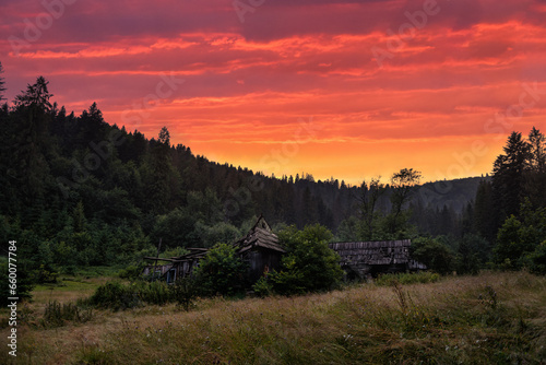 Riuns of old wooden house in moutains at sunset © Antonio