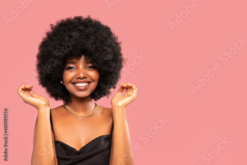 Fashion studio portrait of beautiful smiling woman with afro curls hairstyle. Beauty face of cheerful girl. Real people emotions.