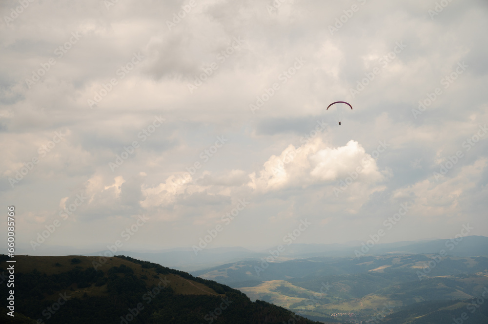 parachutist in the sky above the mountains in the valley, active recreation in the Ukrainian mountains parachutist in the sky above the mountains in the valley, active recreation in the Ukrainian mountains