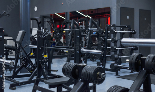 Modern gym. Sports equipment in the gym. Barbells of different weights on a rack.