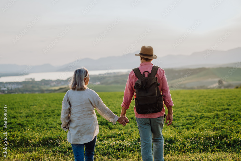 Senior couple walking through the autumn nature with beautiful view of the High Tatras. Mushroom hunting, mushrooming or mushroom picking.