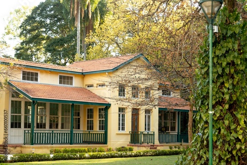 Casa amarela de arquitetura clássica com amplo jardim.  photo