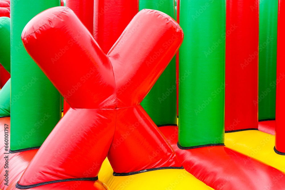 Fragment of inflatable attractions in the form of a red letter X