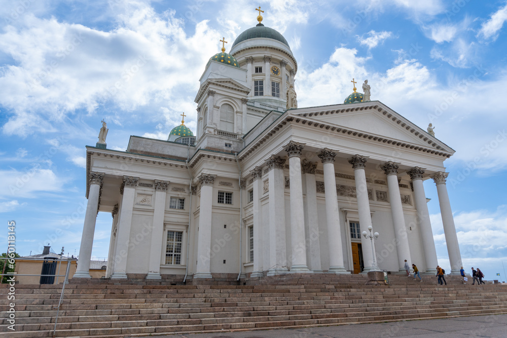 Helsinki Cathedral with people walking, sunny day with some clouds.