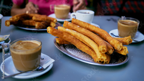 Churros popular deliciuos spanish food with hot chocolate and coffe on restaurant table photo