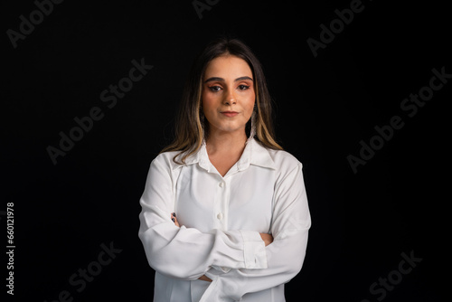 Studio portrait of a beautiful Caucasian woman with blonde hair wearing a white blouse and black shorts.