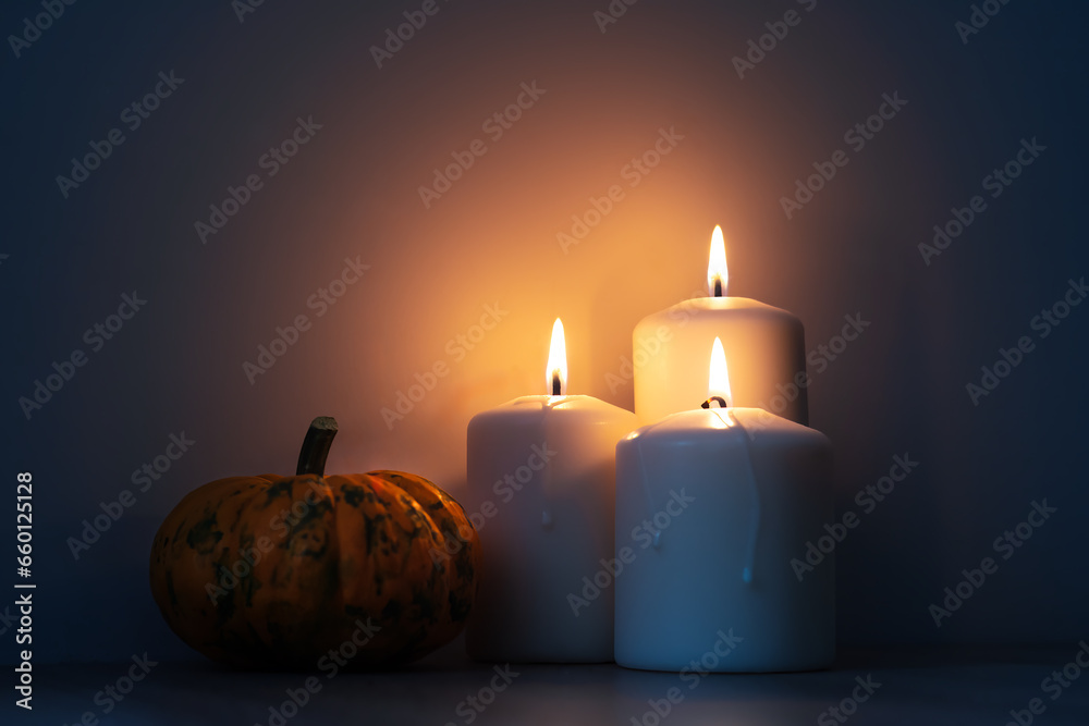 Orange Halloween pumpkins and candles on wooden table, holiday decoration, evening time. Preparation for Halloween celebrating. Orange Halloween pumpkins and candles on wooden table, holiday decoration, evening time. Preparation for Halloween celebrating.