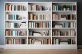 A bookshelf filled with lots of books on white wall.