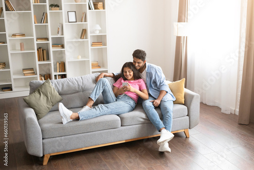 Indian couple using cellphone for online shopping.