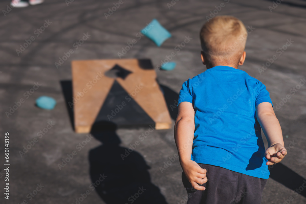 Cornhole game set, process of throwing bean bags, kids children tossing ...