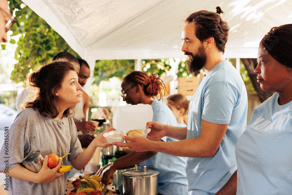 © DC Studio - Multiethnic humanitarian aid team provide essential support to the needy distribute food and offer assistance through local non-profit initiative. Young volunteers share warm meals to the homeless.