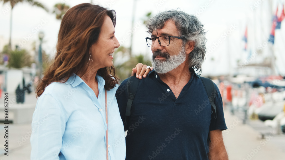 Elderly couple in love happy together, smiling and having conversation, hugging each other, walking together enjoying the day outdoors Elderly couple in love happy together, smiling and having conversation, hugging each other, walking together enjoying the day outdoors