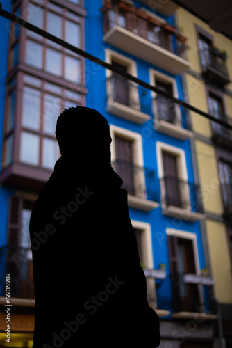 Unrecognizable young boy admires a blue house.