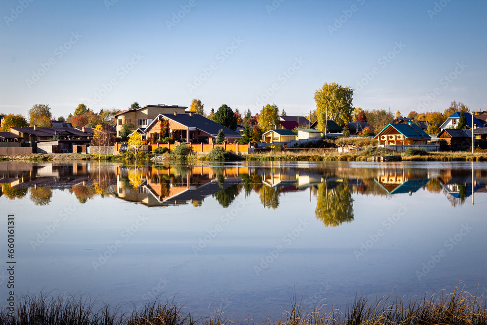Houses in the countryside by the lake on a clear sunny day in autumn