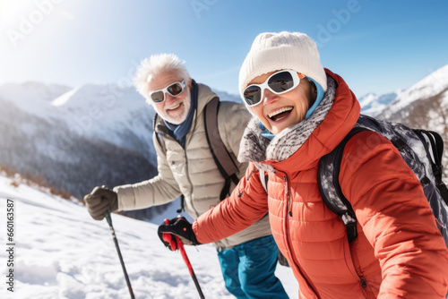 Active senior couple enjoying skiing in mountains with ski poles, displaying joy, embodying a healthy, retired lifestyle. Happy retired couple on winter holidays