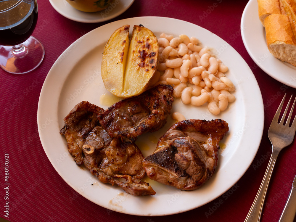 Delicious appetizing fried lamb ribs with boiled potatoes and beans